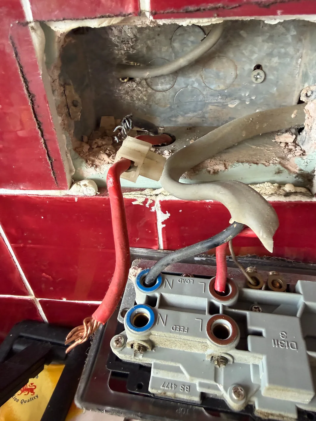Live cabling left exposed in a wall